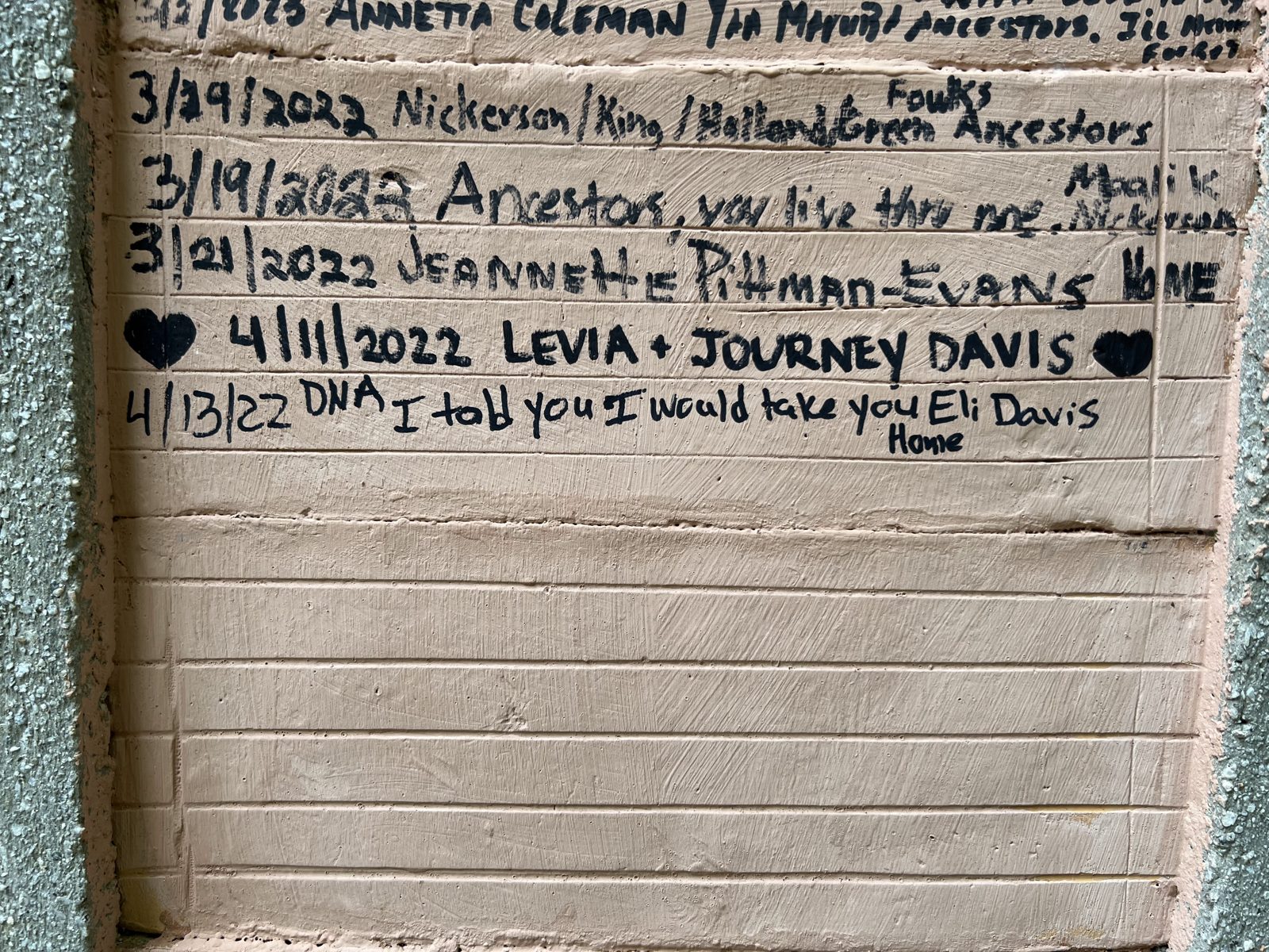 Handwritten inscriptions on the memorial wall at Assin Manso, Ghana, including: I told you I would take you home — Eli Davis